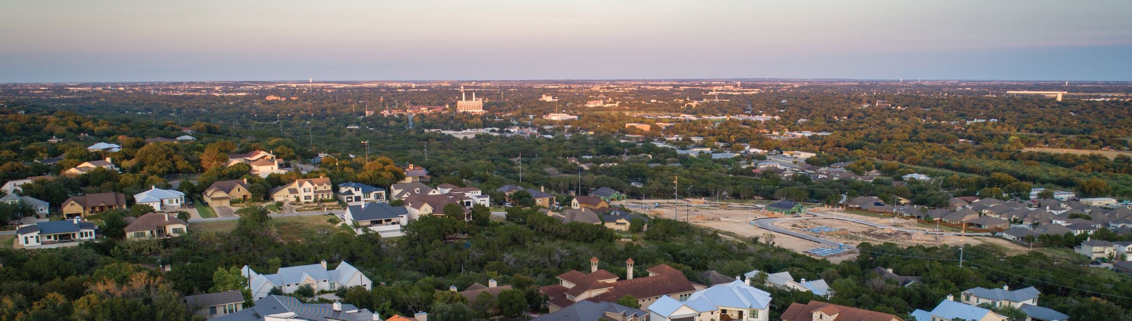 An aerial view of New Braunfels with the horizon in the background at sunset