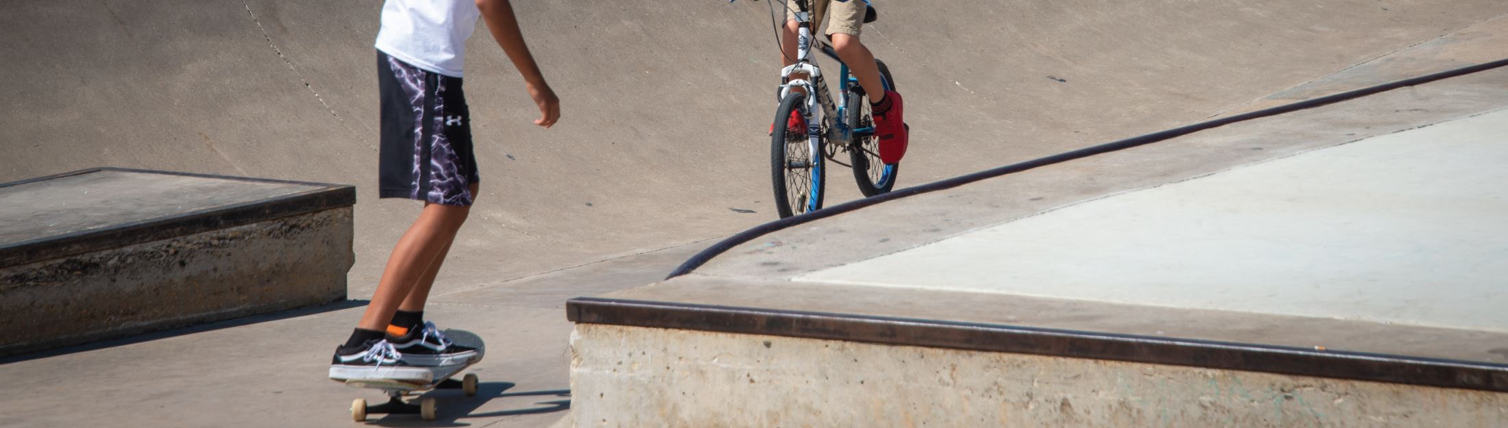 Kids ride skateboards and bicycles at the JAWS Skatepark