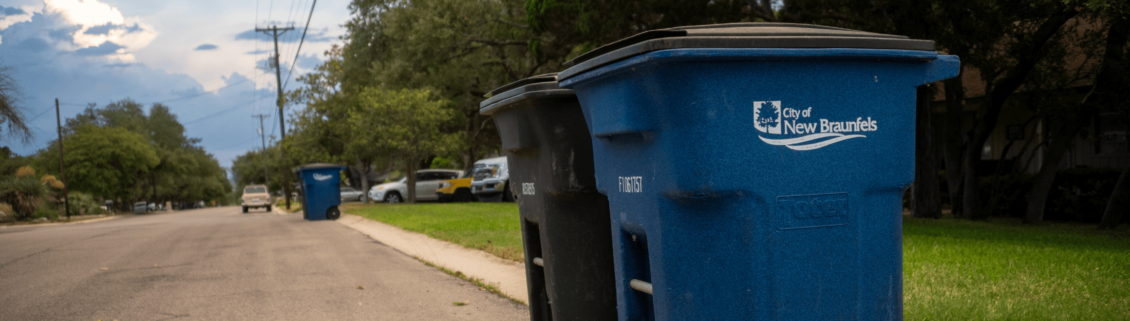 A garbage and recycling can sitting side by side outside